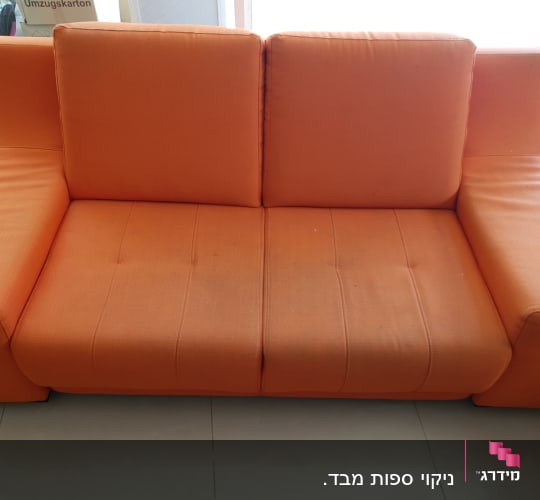ספה כתומה עם כתמים קלים על המושב
